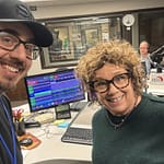 Robbie Daniels, host of the Morning Show on KFGO, posing in the studio with Jeff Carney, owner of DarkHorse IT, in front of microphones and monitors.